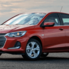 Chevrolet Onix vermelho parado na diagonal.