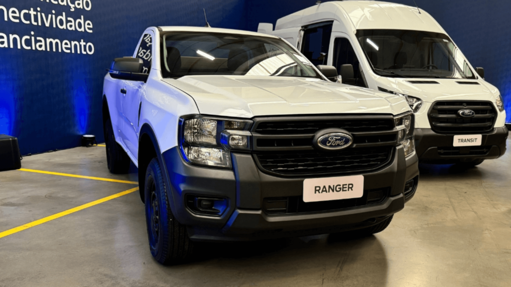 Ford Ranger branca parada do lado de um furgão da Ford.