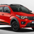 Fiat Mobi vermelho parado no fundo cinza.