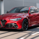 Alfa Romeo vermelho em movimento na estrada.