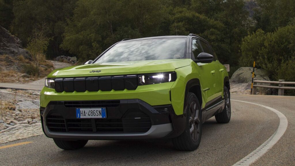 Jeep Compass 2026 verde fazendo uma curva na estrada.