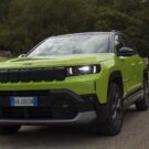 Jeep Compass 2026 verde fazendo uma curva na estrada.