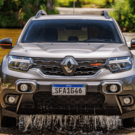 Duster cinza passando em um rio.