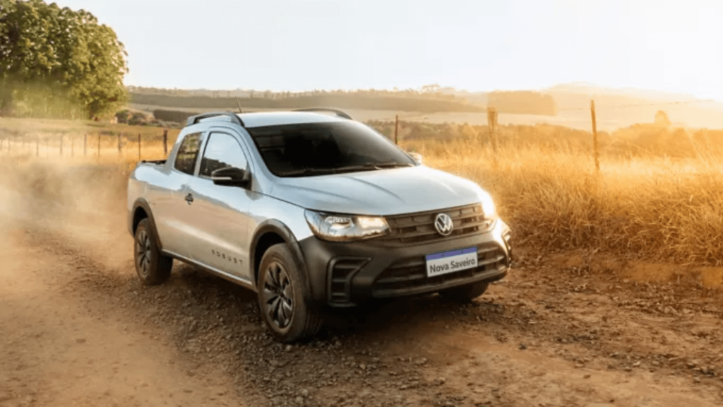 Volkswagen Saveiro prata em movimento na estrada de chão.