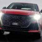 Audi RS Q8 Performance 2026 vermelho em movimento com os faróis acesos.