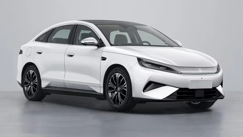 BYD Qin Max branco parado na diagonal.