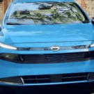 Nissan versa 2027 azul parado de frente.