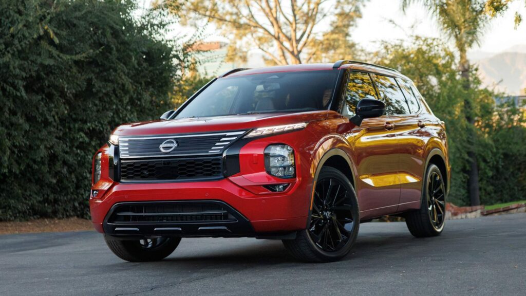 Nissan Rogue vermelho parado na diagonal.