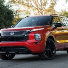 Nissan Rogue vermelho parado na diagonal.