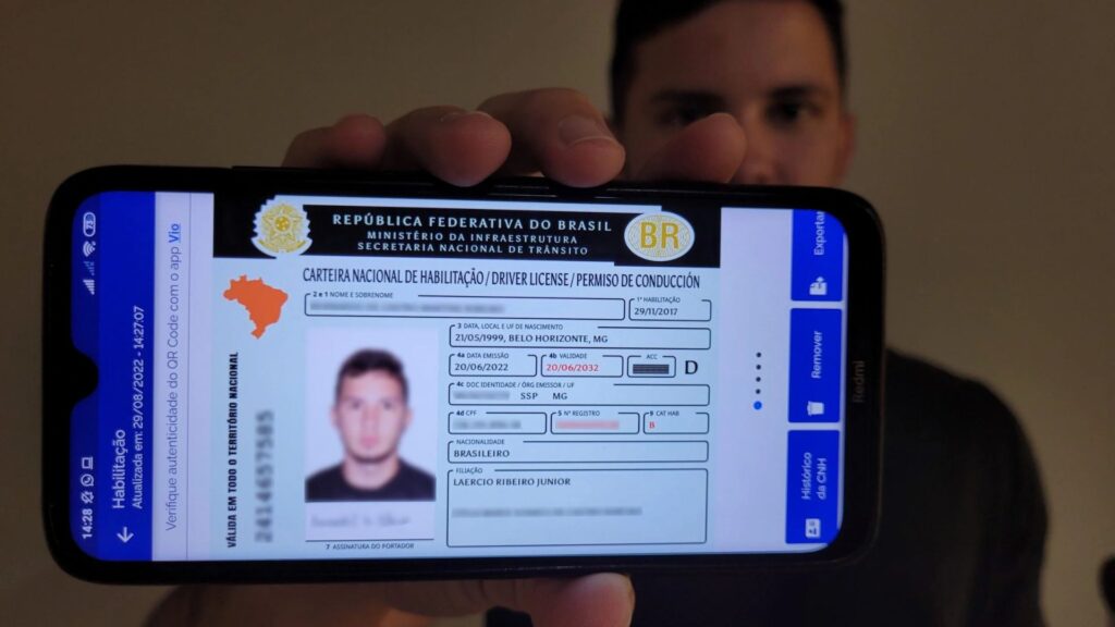 pessoa segurando celular com cnh digital.