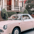 Nissan Figaro rosa na beirada da estrada.