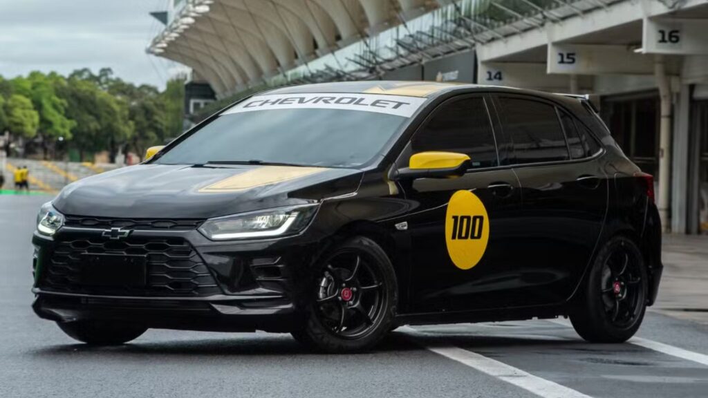 Onix Track Day preto parado na diagonal em uma pista.