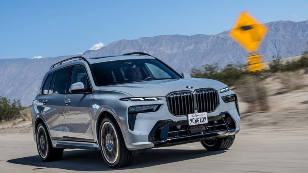 BMW X7 cinza em movimento na estrada.