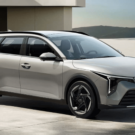 Nova perua da Kia cinza parada na diagonal.