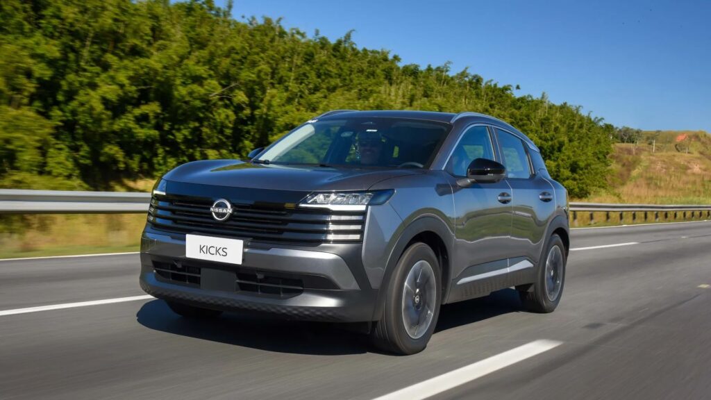 Nissan Kicks cinza em movimento na estrada.