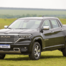 RAM Rampage Laramie 2.2 diesel cinza parado na diagonal em cima de um gramado.