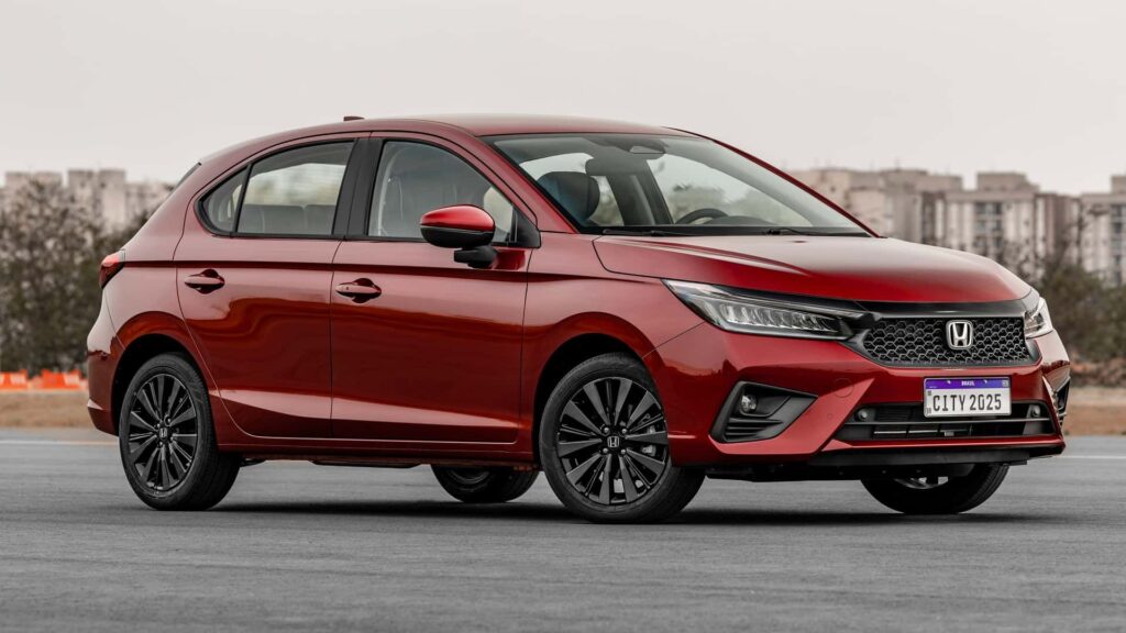 Honda City Hatch vermelho parado na diagonal.