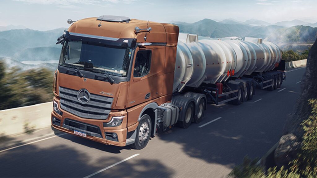 Mercedes-Benz Actros 2653 laranja em movimento na estrada.