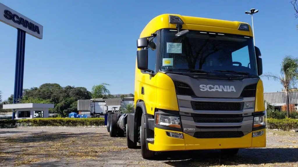 Scania P 360 E6 8x2 amarelo parado na diagonal.