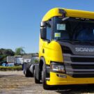 Scania P 360 E6 8x2 amarelo parado na diagonal.