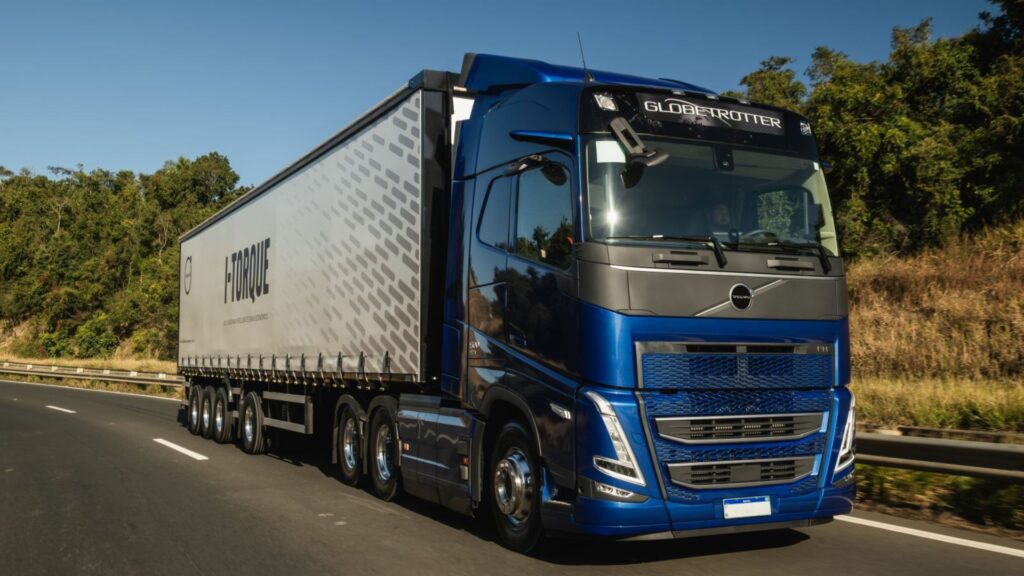 Volvo FH azul em movimento na rodovia.