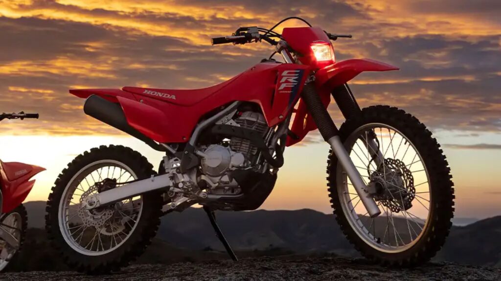 Honda CRF 300F vermelho parado na diagonal.