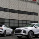 Dois Audi Q3 brancos em frente a fábrica.