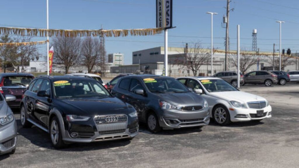 Carros estacionados em pátio.