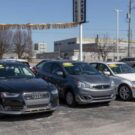 Carros estacionados em pátio.